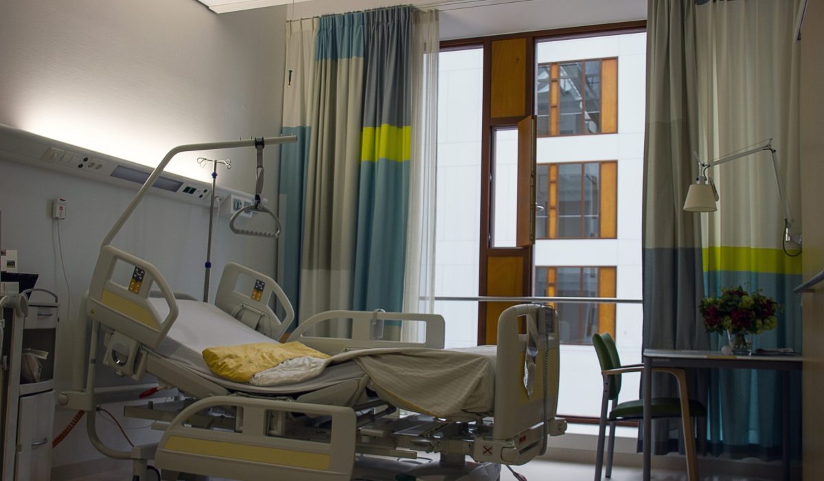 Das Bild zeigt ein leeres Pflegebett in einem Krankenhaus.
