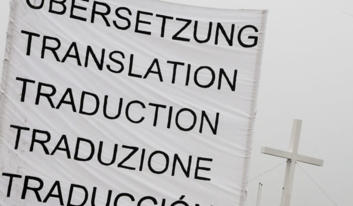 Zeigt ein Banner, auf dem in verschiedenen Sprachen das Wort Übersetzung steht.